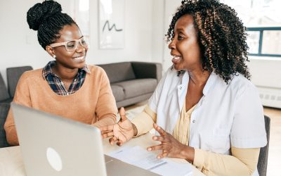 Black women talking in front of a computer