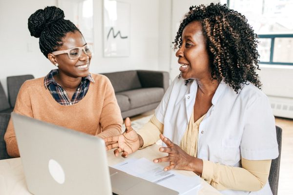 Black women talking in front of a computer