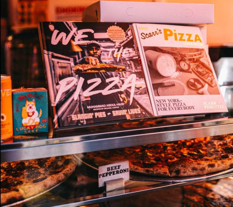 counter at Down North pizza, with a display of magazines and pizza in the glass case