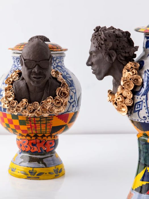 two vases with human head figures coming out of it, with graffiti-like designs and gold roses