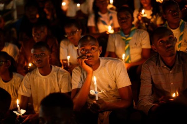 people holding candles for memorial services