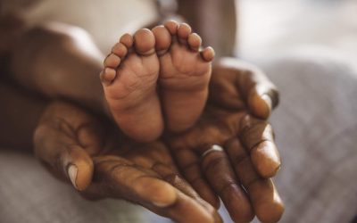 hands of a mother holding the feet of her baby