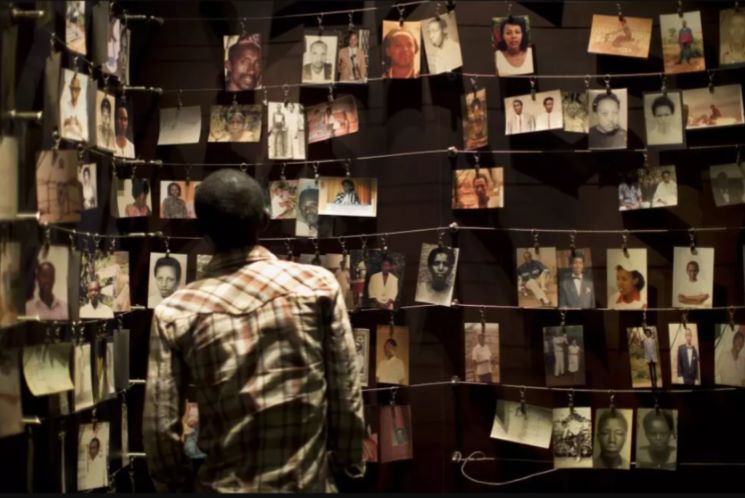 man looking at photographs on display of victims