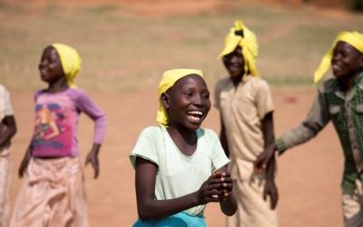 Burundi children wearing yellow headscarves, smiling outdoors