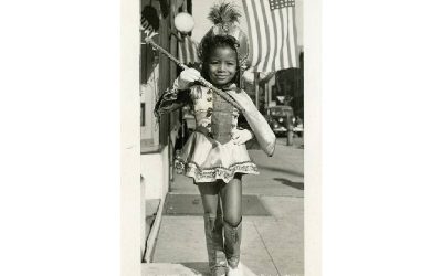 young girl twirling baton in costume