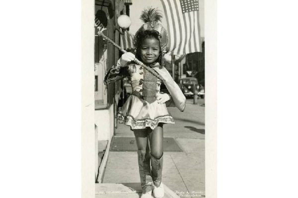 young girl twirling baton in costume