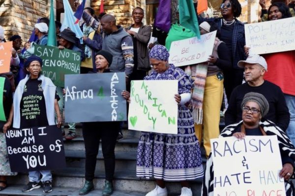 group of protestors, some in traditional attire, with slogans for Africans and anti-xenophobia
