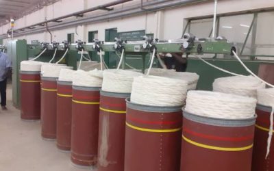 inside a factory showing machinery processing cotton