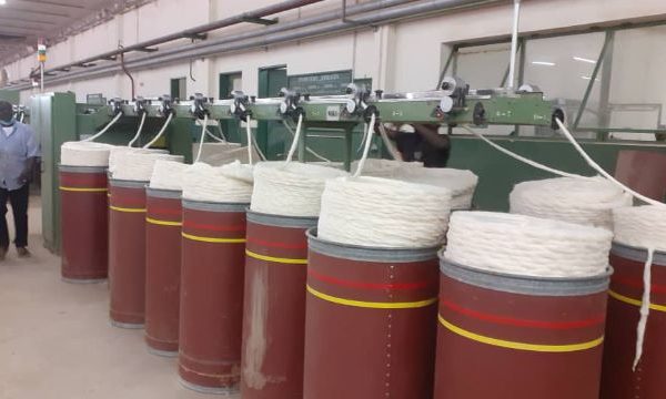 inside a factory showing machinery processing cotton