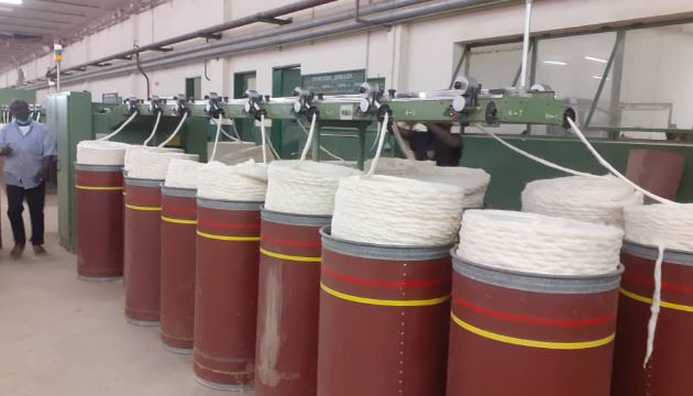 inside a factory showing machinery processing cotton