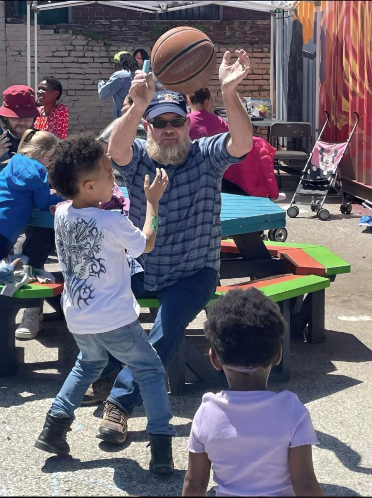 man passing basketball to kids