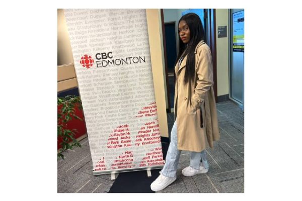 photo of Gift Wogu, in front of a banner that says CBC Edmonton