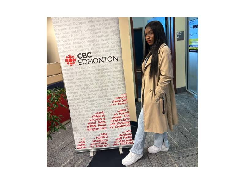 photo of Gift Wogu, in front of a banner that says CBC Edmonton