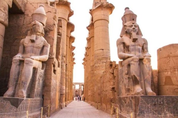 ancient Egyptian temple with columns and seated statues