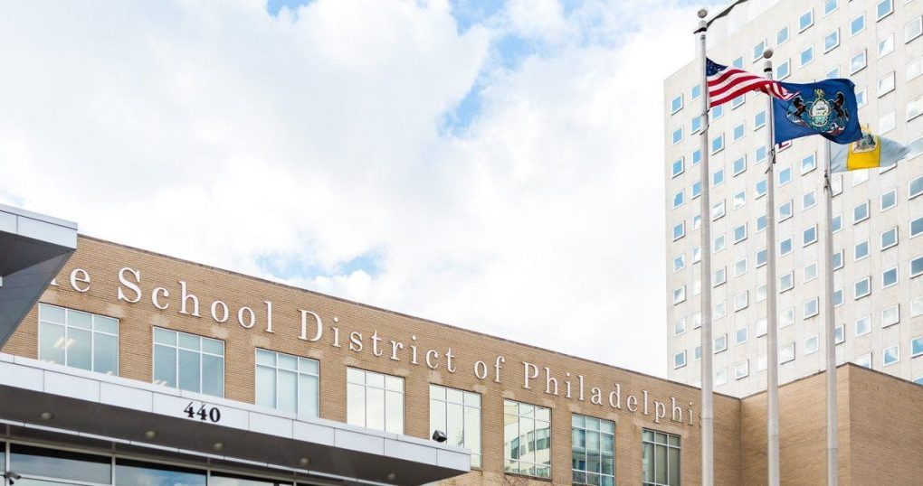 photograph of the Philadelphia School District building with the American flag, and the Philadelphia state flag outside