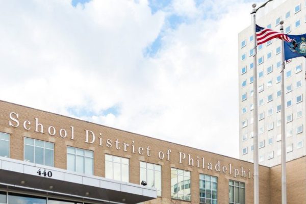 photograph of the Philadelphia School District building with the American flag, and the Philadelphia state flag outside