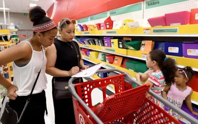 a Black family checking their shopping list in the school supplies aisle at Target