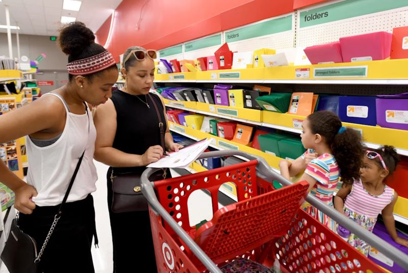 a Black family checking their shopping list in the school supplies aisle at Target